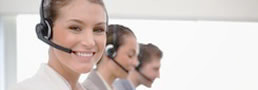 Smiling lady and colleagues provides information by phone - Link zu 